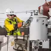tech - worker man in hard hat turning bolt with wrench