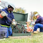 Workers managing underground wiring