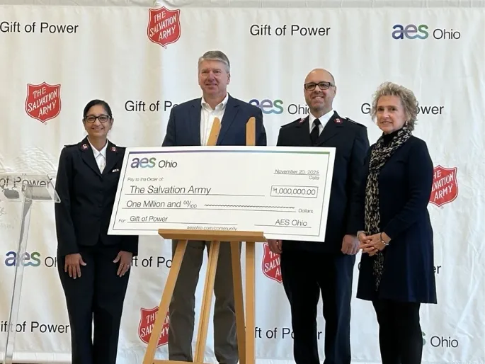 Four people standing behind a large check for the Gift of Power program